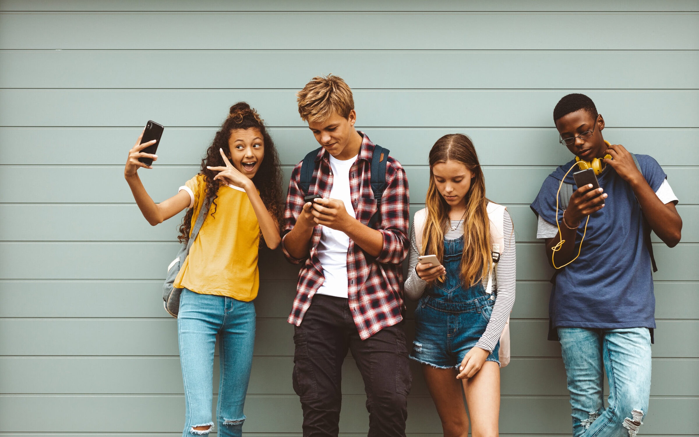 teenage friends looking at their mobile phones