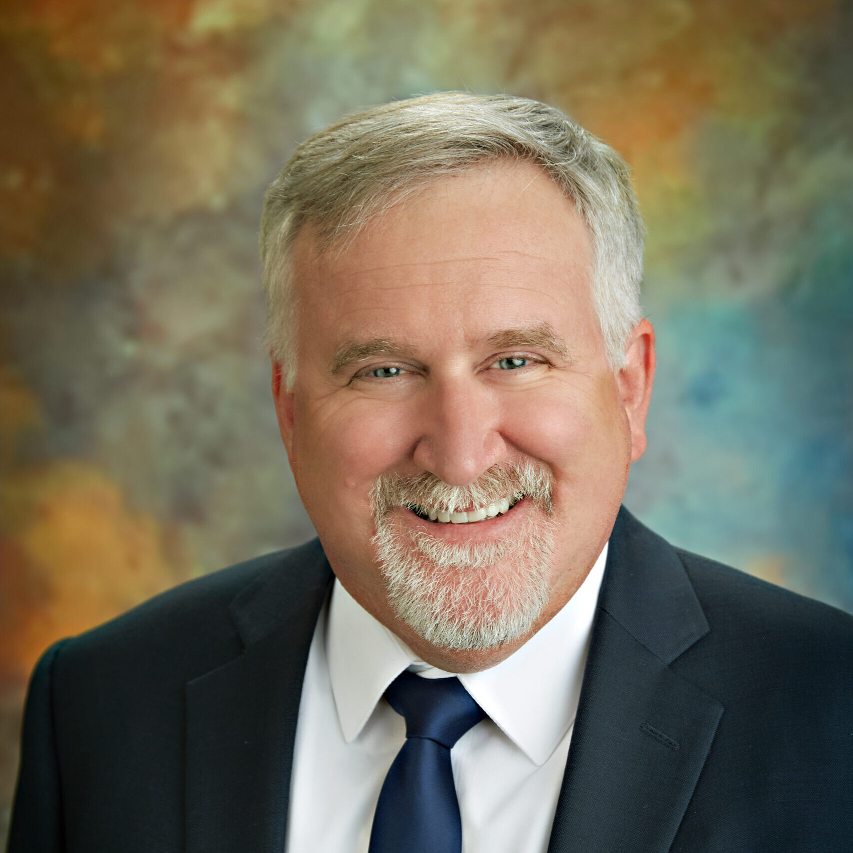 A man in a suit smiling